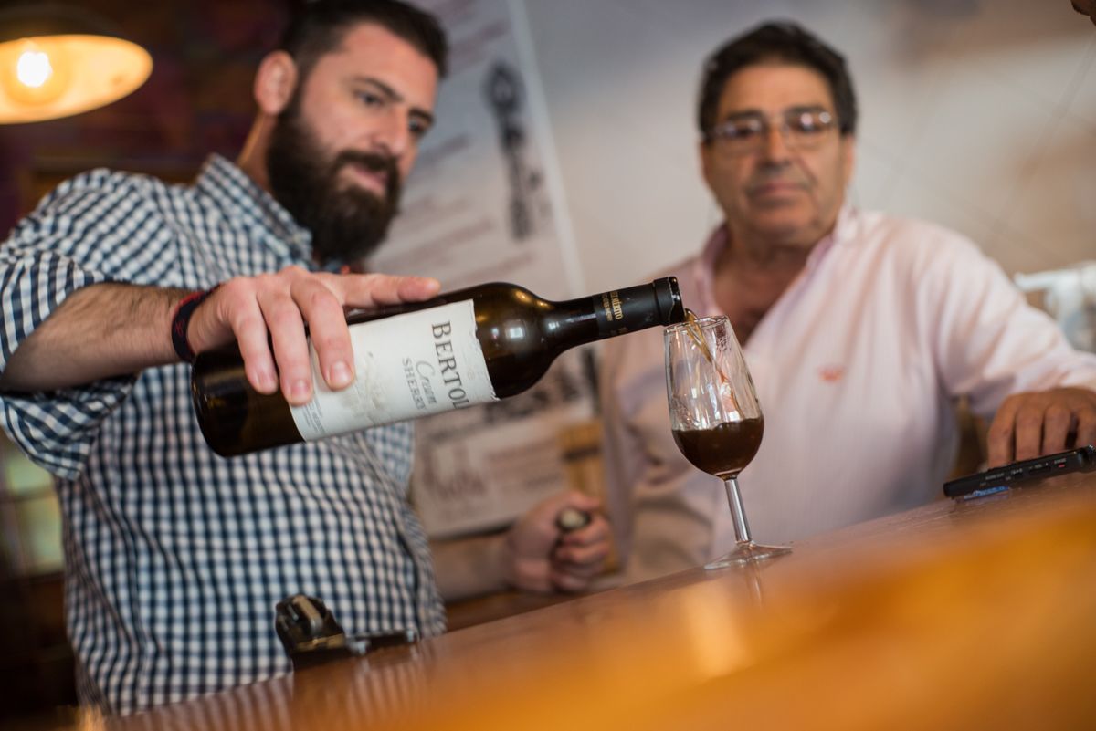 Daniel, del Rody, sirve una copa de jerez bajo la mirada de su padre, José Luis. FOTO: MANU GARCÍA.
