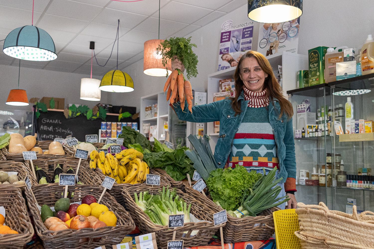 Mabel junto a las frutas y verduras de huertos ecológicos.