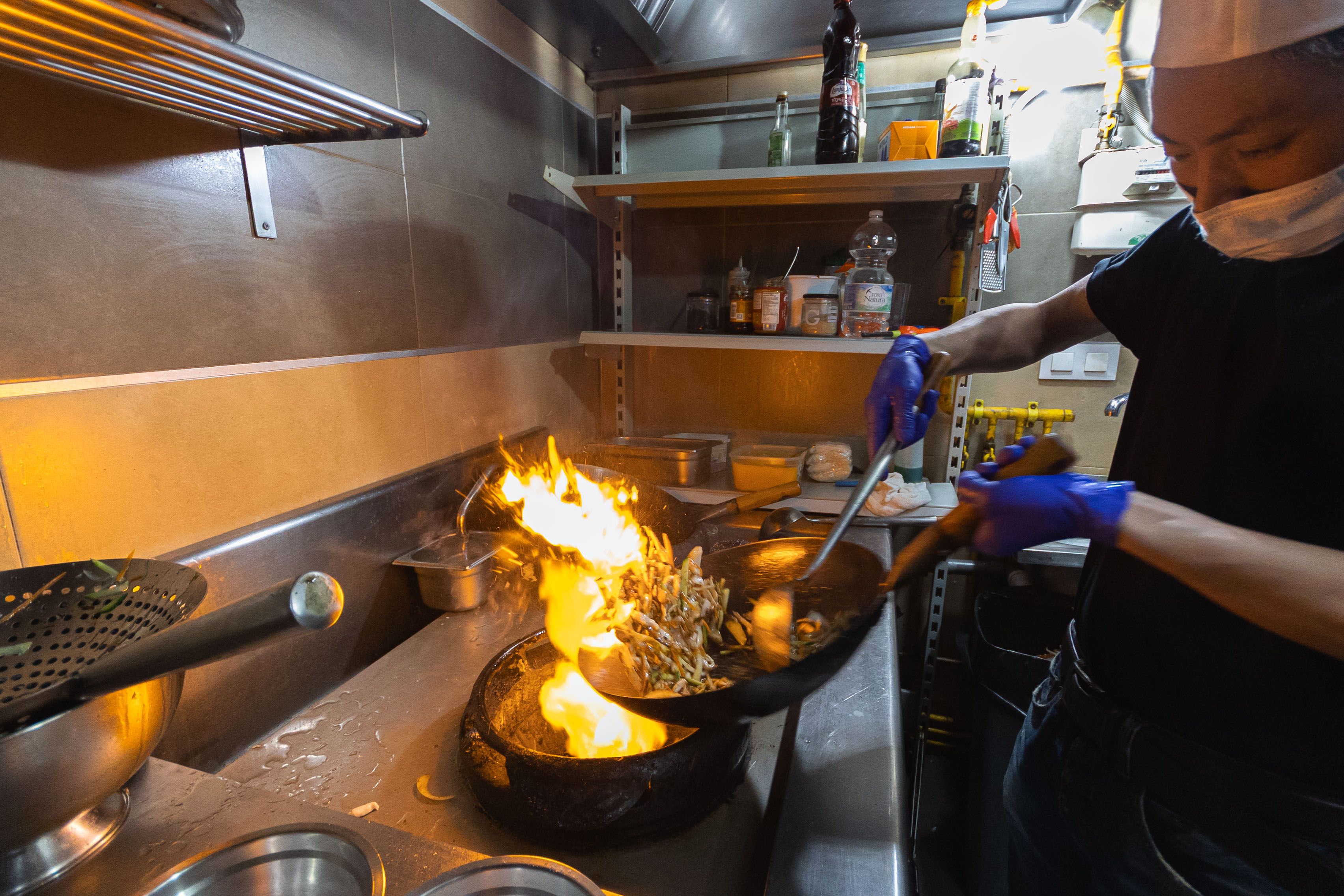 Haiu preparando un wok en la cocina.